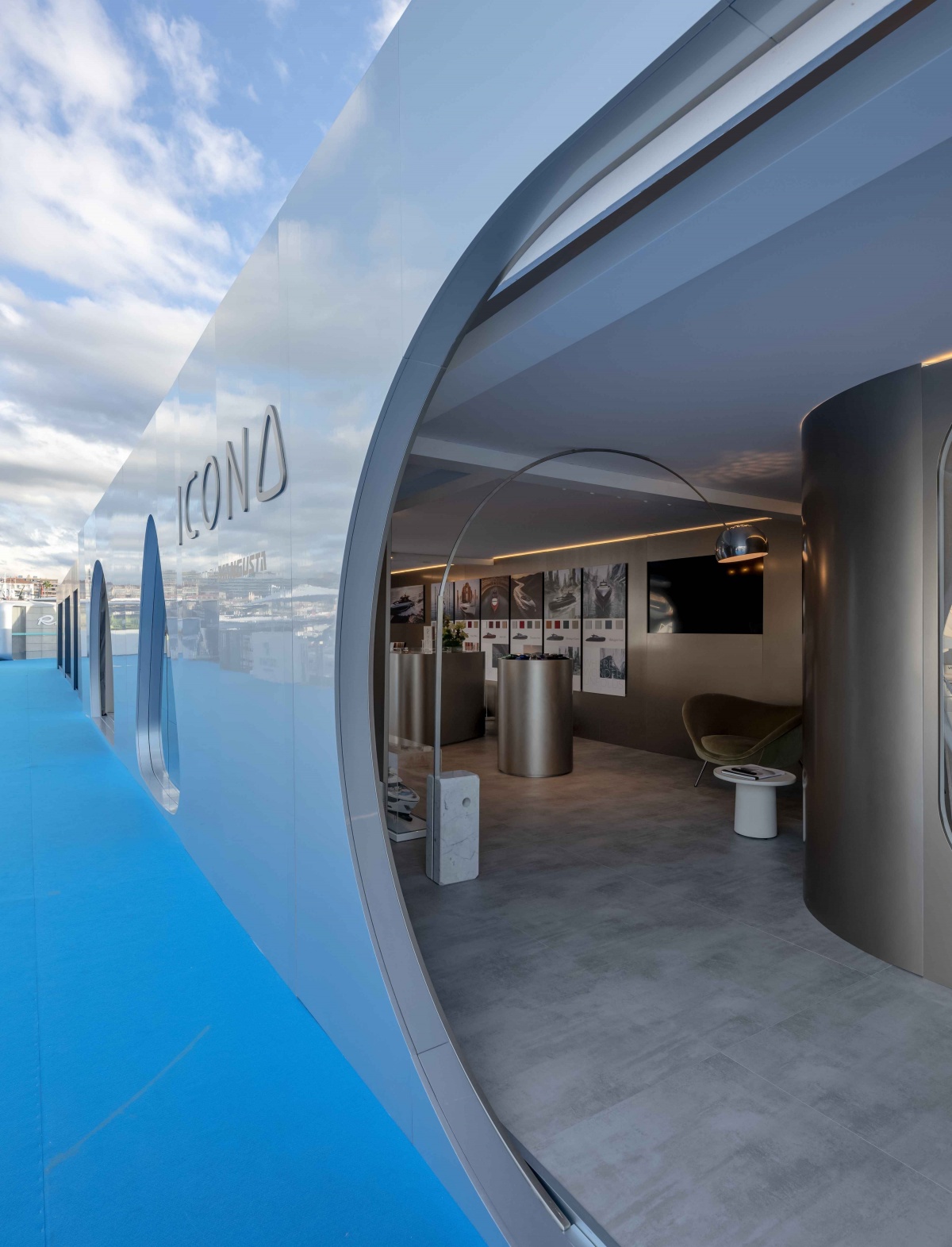 Interior of the Mangusta stand at Cannes Yachting Festival, featuring metallic surfaces, lighting and bespoke details